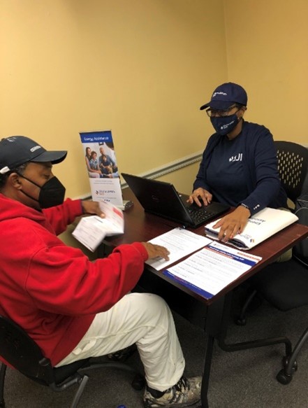 A couple of men wearing helmets and sitting at a table with papers